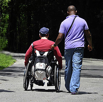 helping Mary Centre friend pushing a wheelchair